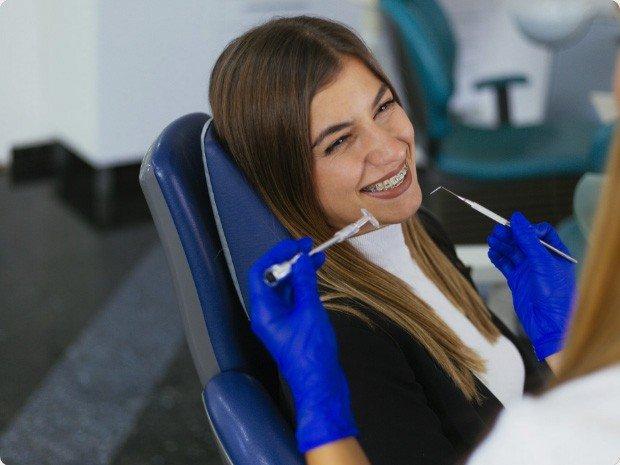 Uśmiechnięta pacjentka na fotelu stomatologicznym